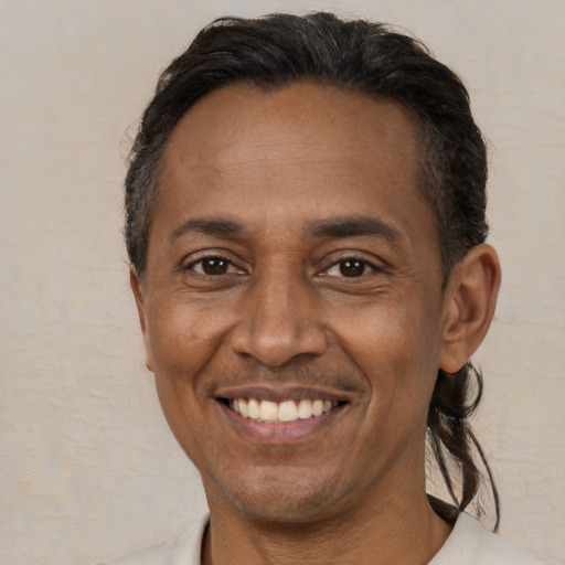 Joyful black adult male with short  brown hair and brown eyes