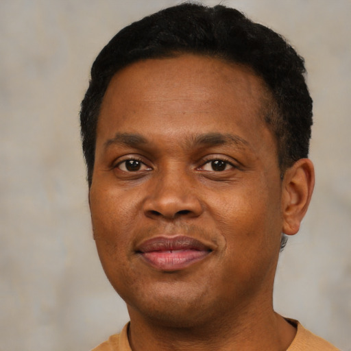 Joyful black young-adult male with short  brown hair and brown eyes