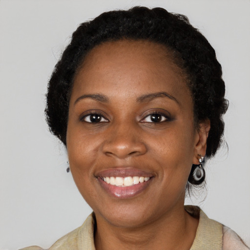 Joyful black adult female with medium  black hair and brown eyes