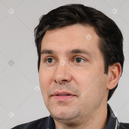 Joyful white adult male with short  black hair and brown eyes