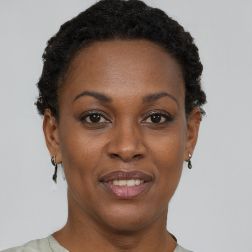 Joyful black young-adult female with short  brown hair and brown eyes