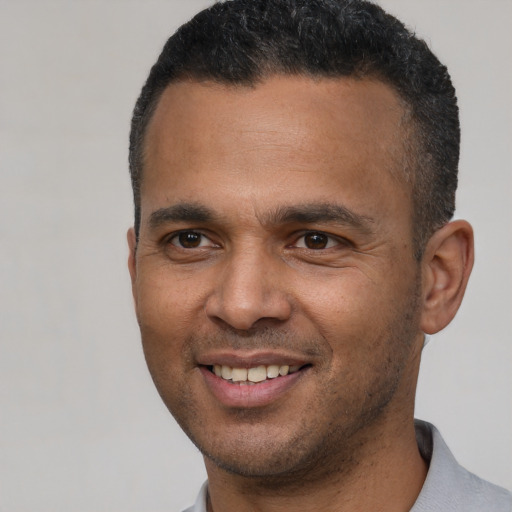 Joyful latino young-adult male with short  brown hair and brown eyes