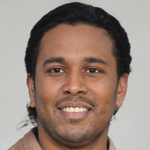 Joyful latino young-adult male with short  black hair and brown eyes