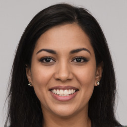 Joyful latino young-adult female with long  brown hair and brown eyes