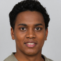 Joyful black young-adult male with short  black hair and brown eyes