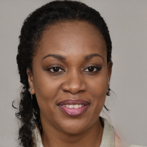 Joyful black adult female with long  brown hair and brown eyes