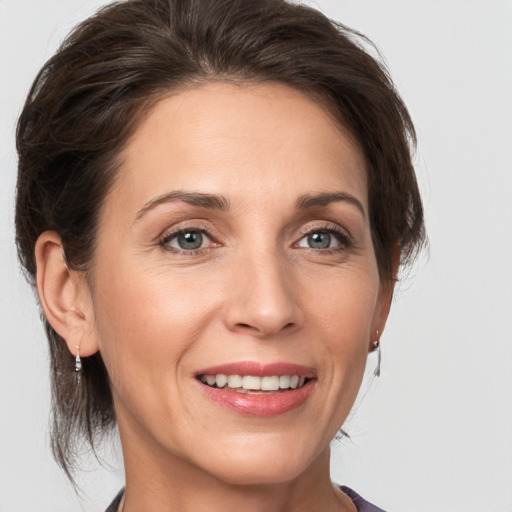 Joyful white adult female with medium  brown hair and grey eyes