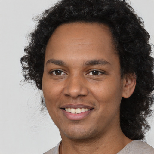 Joyful black young-adult male with short  black hair and brown eyes