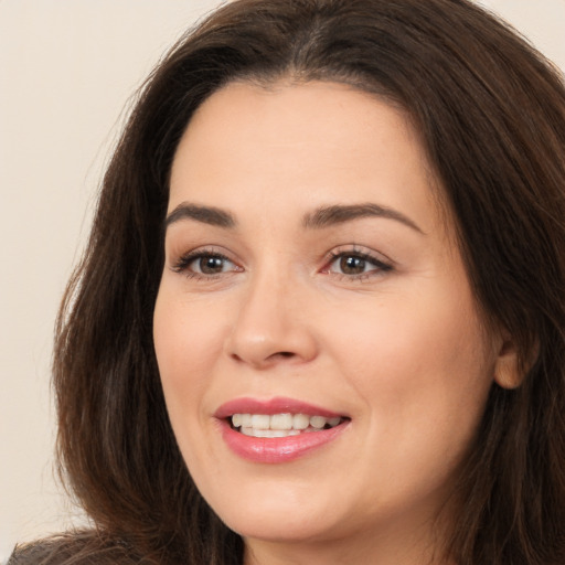 Joyful white young-adult female with long  brown hair and brown eyes