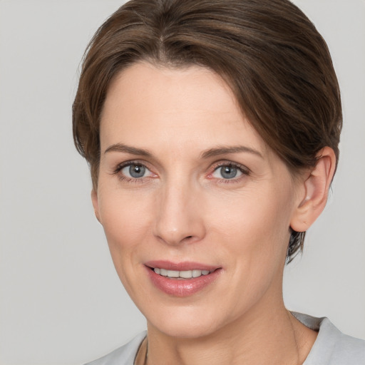 Joyful white young-adult female with medium  brown hair and grey eyes