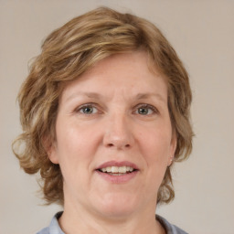 Joyful white adult female with medium  brown hair and blue eyes