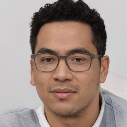 Joyful white young-adult male with short  black hair and brown eyes