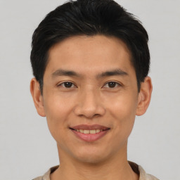 Joyful asian young-adult male with short  black hair and brown eyes