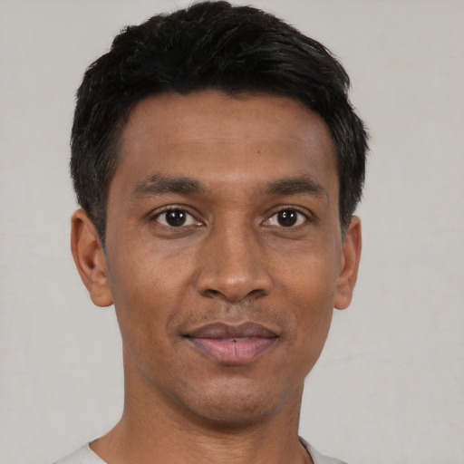 Joyful black young-adult male with short  black hair and brown eyes