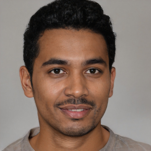 Joyful latino young-adult male with short  black hair and brown eyes