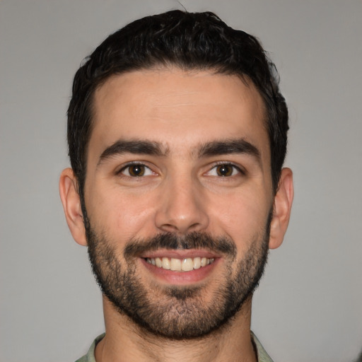 Joyful white young-adult male with short  black hair and brown eyes