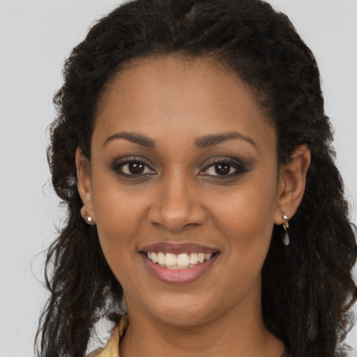 Joyful black young-adult female with long  brown hair and brown eyes