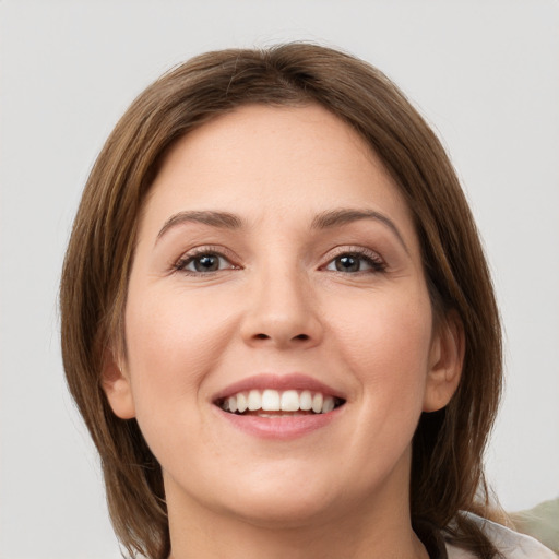 Joyful white young-adult female with medium  brown hair and grey eyes