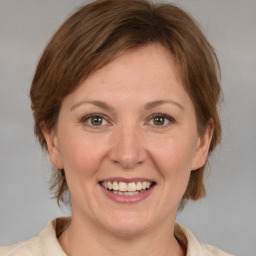 Joyful white adult female with medium  brown hair and grey eyes