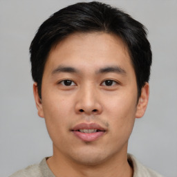 Joyful asian young-adult male with short  black hair and brown eyes