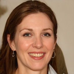 Joyful white young-adult female with medium  brown hair and blue eyes