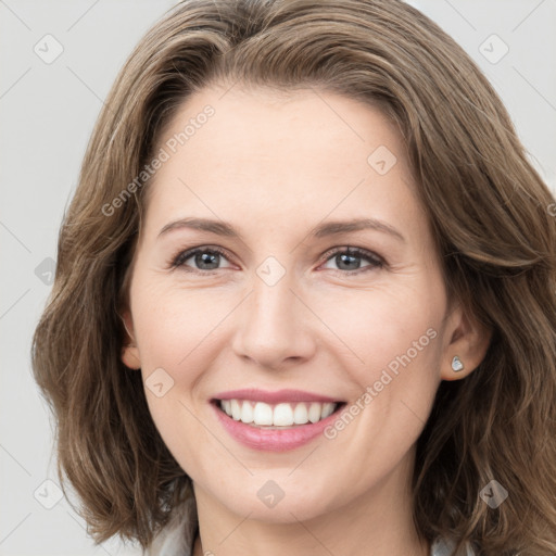 Joyful white young-adult female with long  brown hair and grey eyes