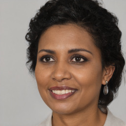 Joyful black adult female with medium  brown hair and brown eyes