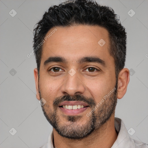 Joyful white adult male with short  black hair and brown eyes