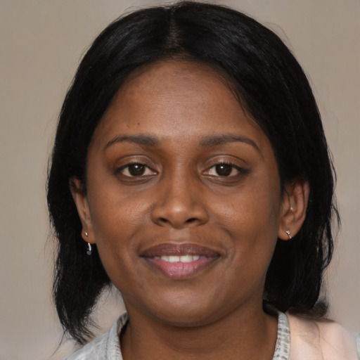 Joyful black adult female with medium  black hair and brown eyes