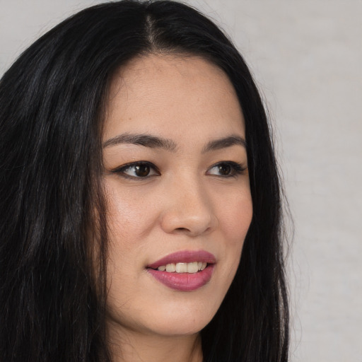 Joyful asian young-adult female with long  brown hair and brown eyes