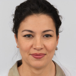 Joyful latino young-adult female with medium  brown hair and brown eyes