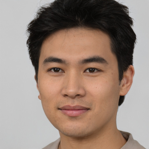 Joyful asian young-adult male with short  black hair and brown eyes