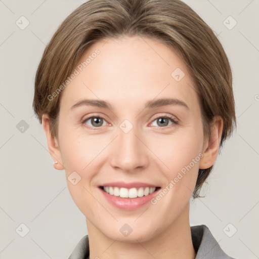 Joyful white young-adult female with medium  brown hair and grey eyes