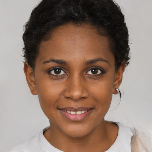 Joyful black young-adult female with short  brown hair and brown eyes