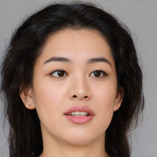 Joyful asian young-adult female with long  brown hair and brown eyes