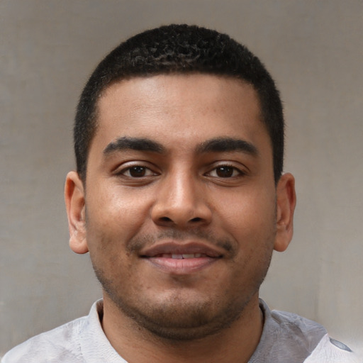 Joyful black young-adult male with short  black hair and brown eyes