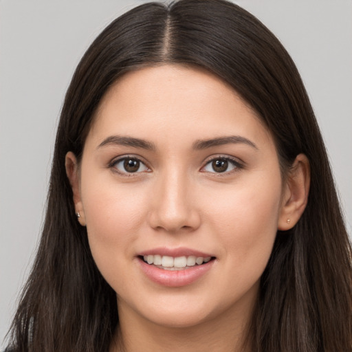 Joyful white young-adult female with long  brown hair and brown eyes