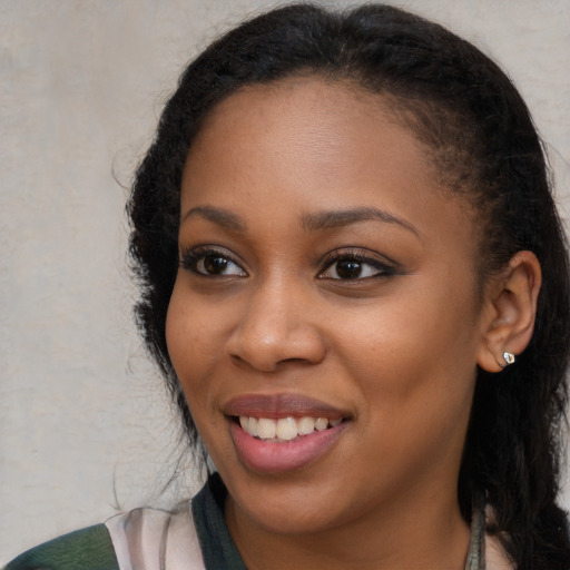 Joyful black young-adult female with long  brown hair and brown eyes