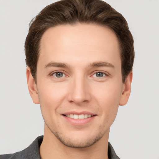 Joyful white young-adult male with short  brown hair and grey eyes