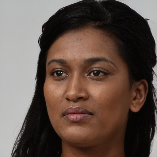 Joyful black young-adult female with long  black hair and brown eyes