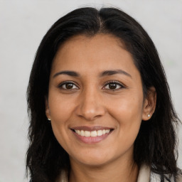 Joyful latino young-adult female with long  brown hair and brown eyes