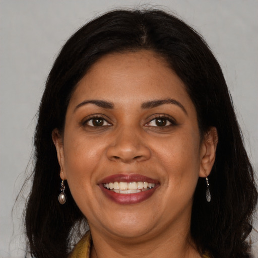 Joyful black adult female with long  brown hair and brown eyes