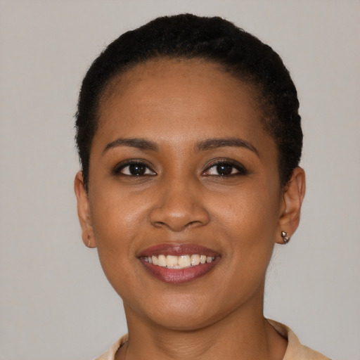 Joyful black young-adult female with short  brown hair and brown eyes