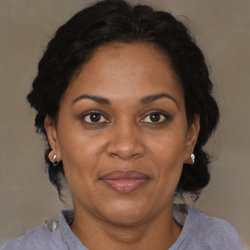 Joyful black adult female with medium  brown hair and brown eyes