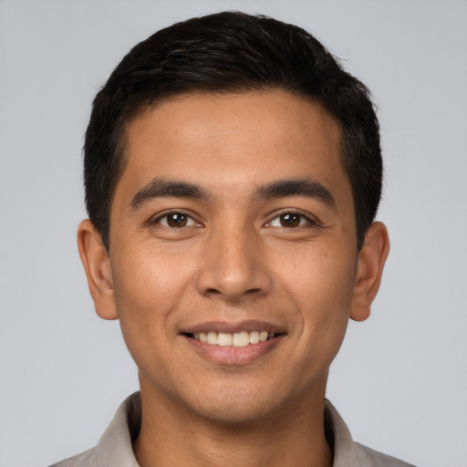 Joyful latino young-adult male with short  brown hair and brown eyes