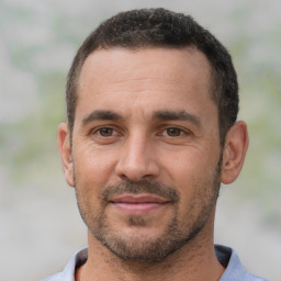 Joyful white adult male with short  black hair and brown eyes