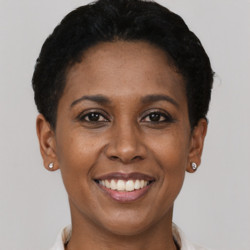 Joyful black young-adult female with short  black hair and brown eyes