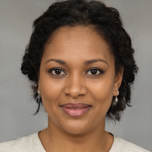 Joyful black young-adult female with medium  brown hair and brown eyes