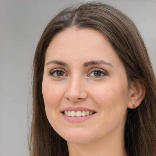 Joyful white young-adult female with long  brown hair and brown eyes