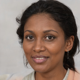 Joyful black adult female with medium  brown hair and brown eyes